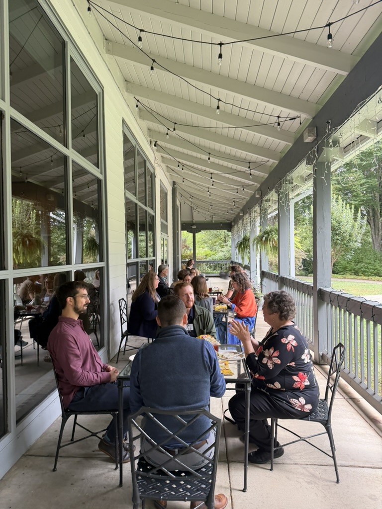 Attendees sharing a meal on the Arboretum porch
