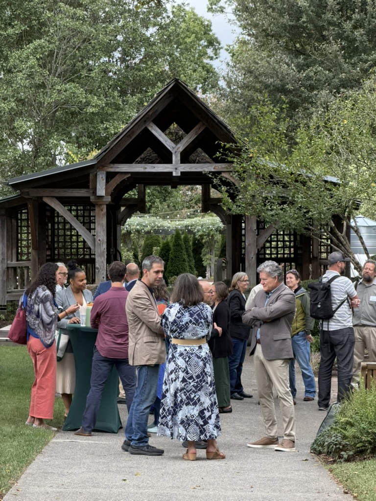 Attendees gathering outdoors at an Arboretum pavilion